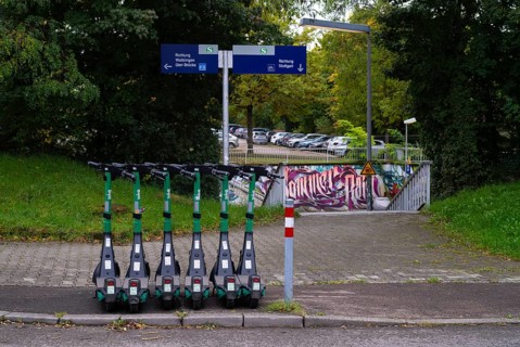Several e-scooters, electric scooters, scooters parked on the pavement, pavement, in the Bolt bike