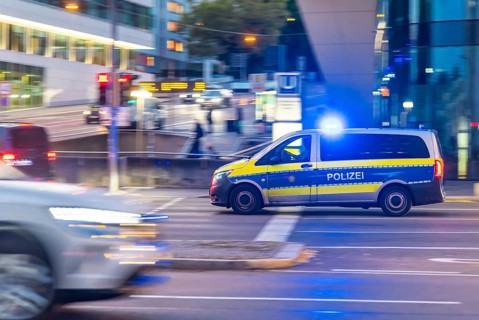 Police vehicle with flashing blue lights in an urban environment. Pulling along. Stuttgart,