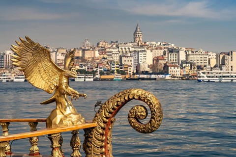 Golden oriental restaurant ship on the banks of Eminönü, Beyoglu and the Galata Tower, Istanbul,