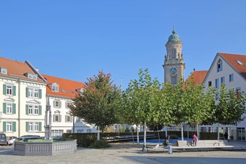 Obertorplatz with church tower of the collegiate church of St James, benches, people sitting,
