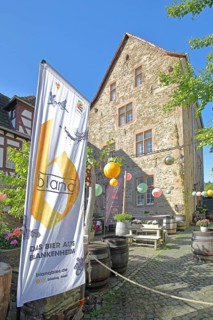 Banner with beer brand, lanterns and courtyard with wine barrels, flag, inscription, Blankenheim,