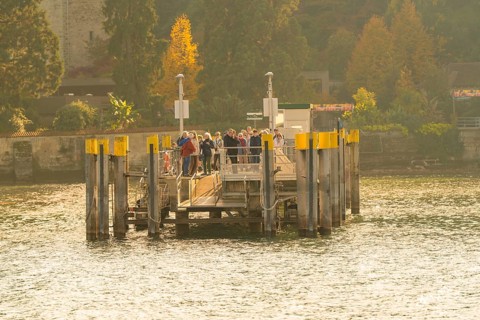 Group of people gathering on a jetty in sunny autumn weather, Mainau Island, Lake Constance,