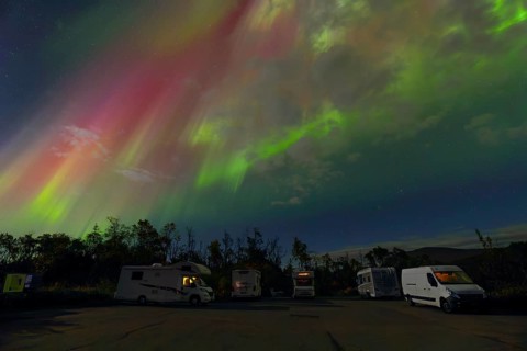 Where heaven and earth shine - campers under the dancing Northern Lights in Scandinavia