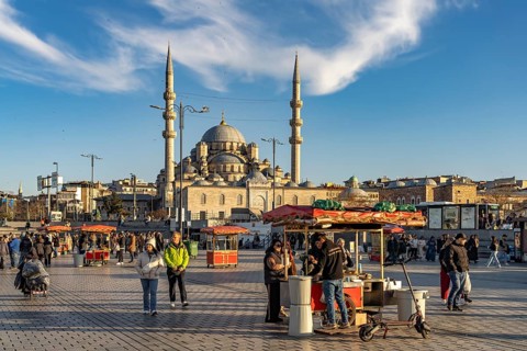 Stand with corn and chestnuts on Eminönü Square Eminönü Meydani and the New Mosque Yeni Cami in