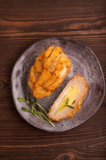 Chicken Schnitzel on gray plate with microgreen on brown wooden background. top view, flat lay,