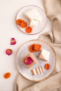 Cocoa and milk jelly with dried apricots on white wooden background and linen textile, top view,