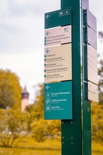 Signpost with various information in a park against an autumnal background, Mainau Island, Lake
