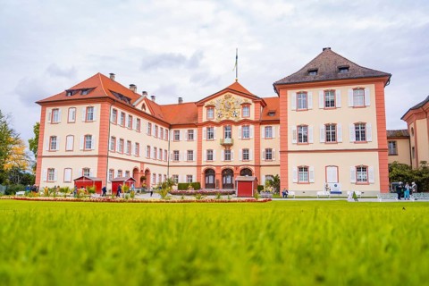 Historic castle with large lawn and sky in the background, Mainau flower island, Lake Constance,