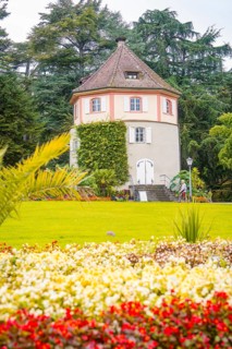 Round tower in the garden, surrounded by blooming flowers, Mainau flower island, Lake Constance,