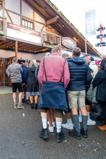 Group of people in traditional Bavarian traditional costume in front of a venue, Cannstatter Wasen