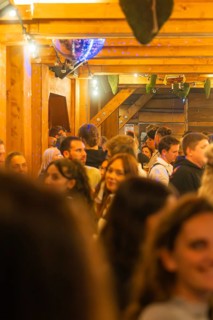 Cramped interior with lots of people, warm light and wooden furnishings, Cannstatter Wasen folk
