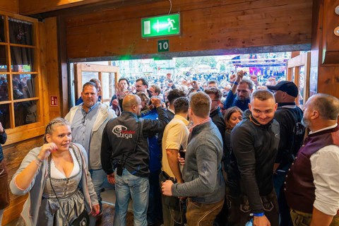 Crowd of people pushing through the entrance of a marquee, lively scene, Cannstatter Wasen folk
