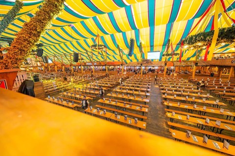 Large marquee with colourful stripes and traditional interior design, Cannstatter Wasen folk