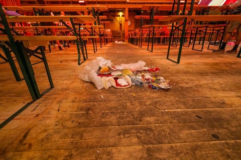 Abandoned interior with wooden benches and rubbish lying on the floor, Cannstatter Wasen folk