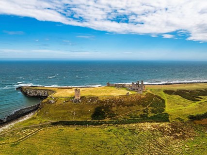 Dunstanburgh Castle from a drone, Northumberland Coast, England, United Kingdom