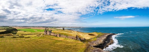 Panorama of Dunstanburgh Castle from a drone, Northumberland Coast, England, United Kingdom