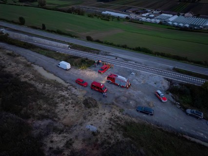 Aerial view of rescue vehicles and personnel near railway tracks and roads, fire drill in the new