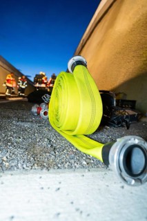 Roll-wound fire hose on the ground at night, fire drill in the new construction tunnel of the