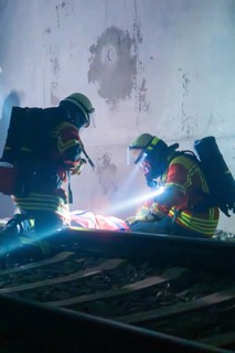 Firefighters provide first aid on tracks in a tunnel, firefighting exercise in the new tunnel of