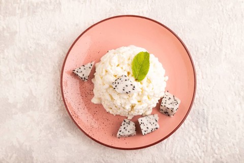 White ?ottage cheese, Curd, with Pithaya on gray concrete background, top view, flat lay, close up