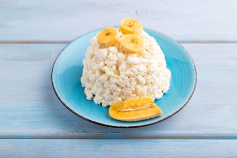 White ?ottage cheese, Curd, with Banana on blue wooden background, side view, close up