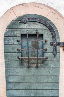Iron fittings and window grilles on an old wooden door, Hesse, Germany