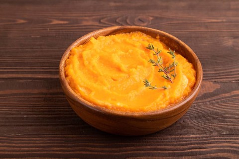 Sweet potato porridge in wooden bowl on wooden background. Diet, healthy eating concept. side view,