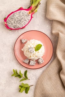 White ?ottage cheese, Curd, with Pithaya on gray concrete background and linen textile, top view,