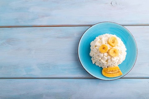 White ?ottage cheese, Curd, with Banana on blue wooden background, top view, flat lay, copy space