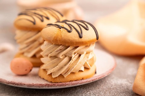 Caramel Cream Cakes on brown concrete background, cup of coffee, side view, close up, selective