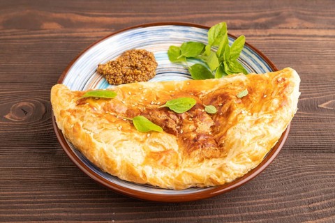 Fried homemade Khachapuri cake with cheese and meat, fried in pan. Traditional Georgian cuisine on