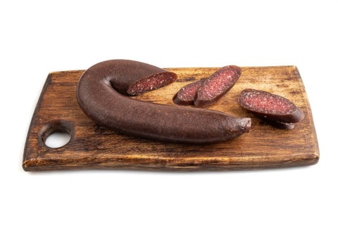 Sujuk sausage isolated on wooden cutting board on white background. Side view, copy space