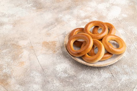 Homemade Ring Bagel on brown concrete background. side view, copy space