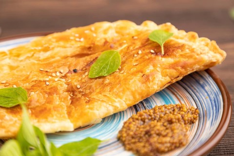 Fried homemade Khachapuri cake with cheese and meat, fried in pan. Traditional Georgian cuisine on