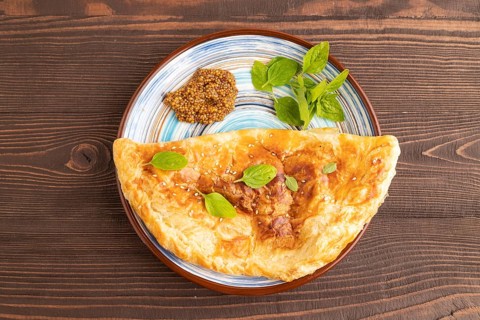 Fried homemade Khachapuri cake with cheese and meat, fried in pan. Traditional Georgian cuisine on