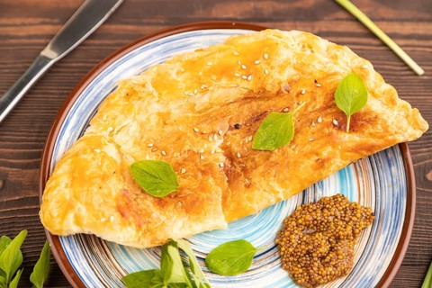 Fried homemade Khachapuri cake with cheese and meat, fried in pan. Traditional Georgian cuisine on