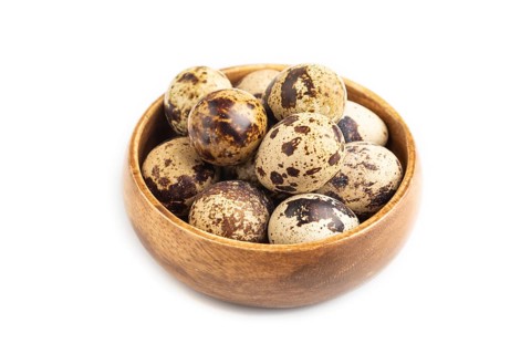 Pile of Raw Quail eggs isolated on white background. side view, close up