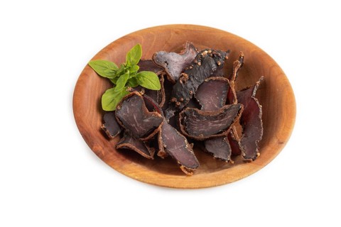 Armenian Basturma dried meat on wooden bowl isolated on white background. Side view