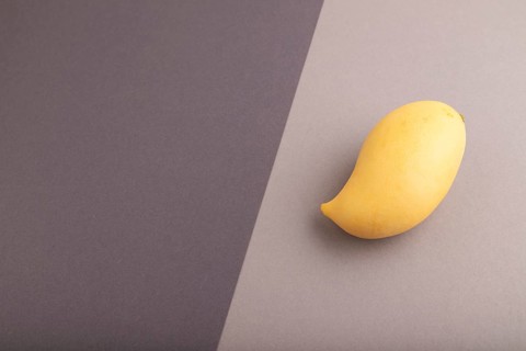 Orange mango on black and gray paper pastel background. Side view, copy space. healthy food,