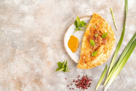 Fried homemade Khachapuri cake with cheese and meat, fried in pan. Traditional Georgian cuisine on