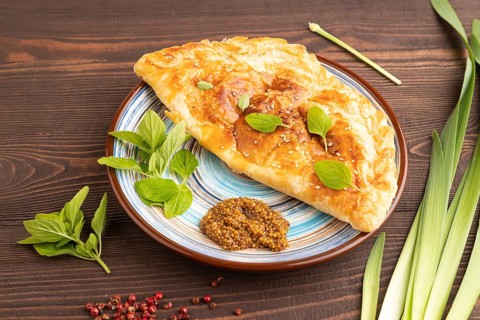 Fried homemade Khachapuri cake with cheese and meat, fried in pan. Traditional Georgian cuisine on