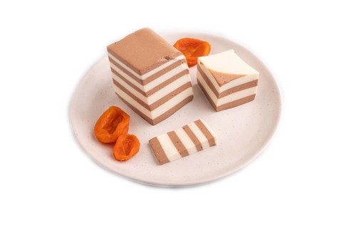 Cocoa and milk jelly with dried apricots isolated on white background, side view, minimalism