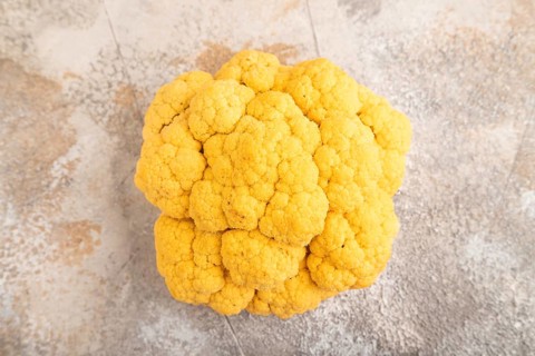 Yellow Cauliflower on brown concrete background. Top view, close up, flat lay. healthy food,