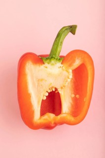 Red Cutted pepper on pink pastel background. Top view, flat lay, copy space. Tropical, healthy