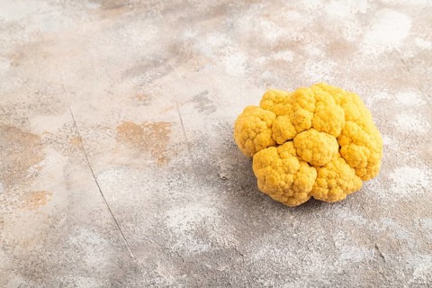 Yellow Cauliflower on brown concrete background. Side view, copy space. healthy food, vegetable,