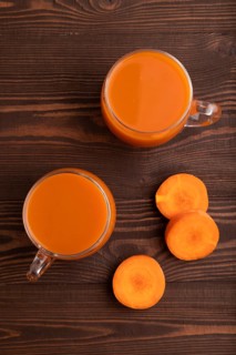 Two glasses with carrot juice, on wooden background. Diet, healthy eating concept. top view, flat
