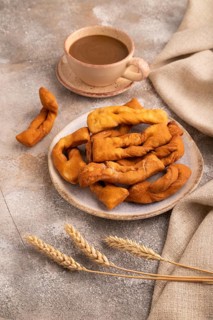 Crunchy biscuit Brushwood cookies sprinkled with powdered sugar on brown concrete background and