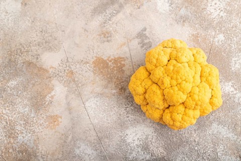 Yellow Cauliflower on brown concrete background. Top view, copy space, flat lay. healthy food,