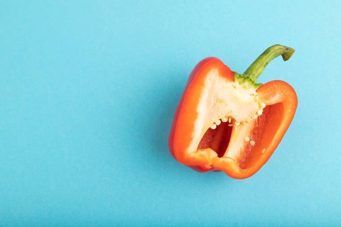 Red Cutted pepper on blue pastel background. Top view, flat lay, copy space. Tropical, healthy