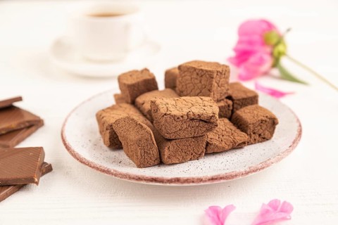 Chocolate marshmallow with cup of coffee on white wooden background. side view, close up, selective